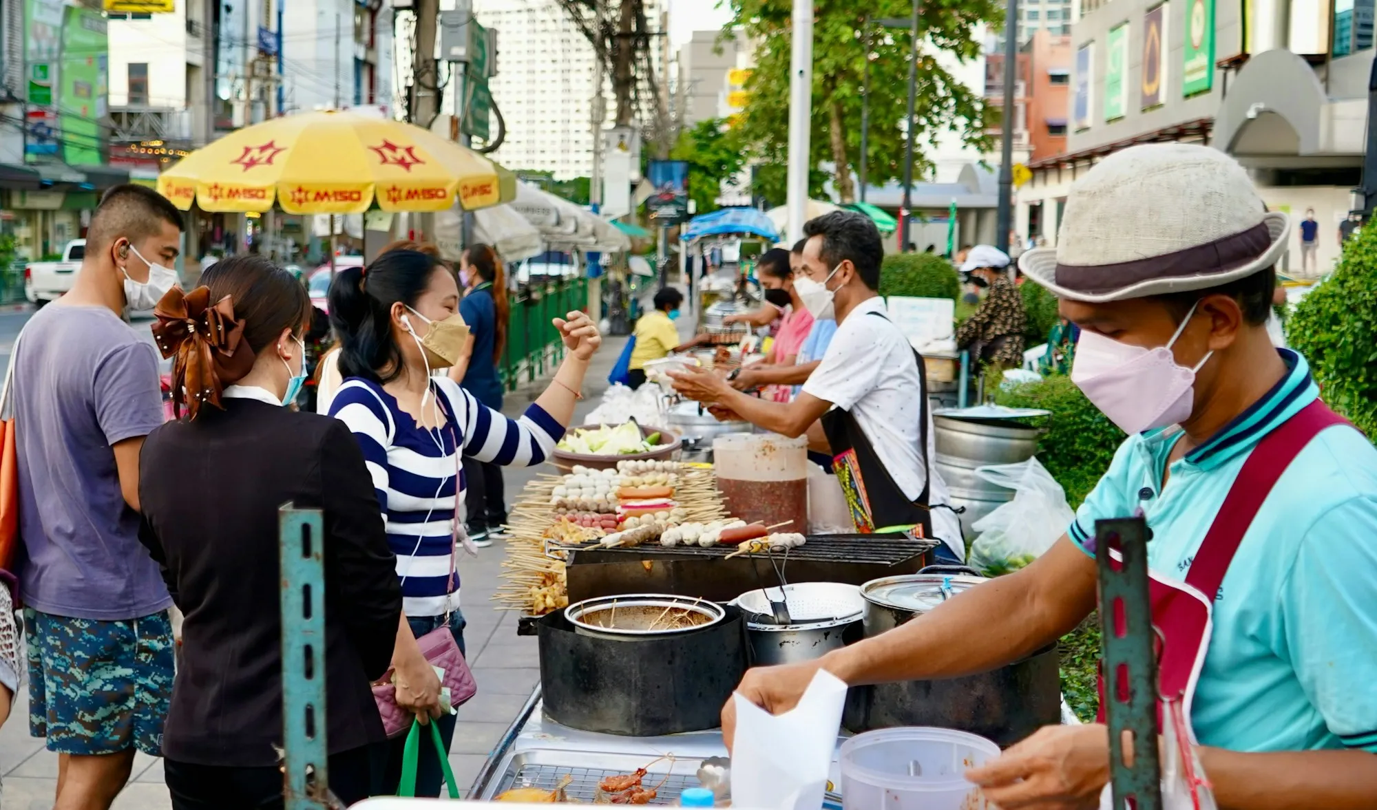 Street food vendors serving customers at a busy roadside stall